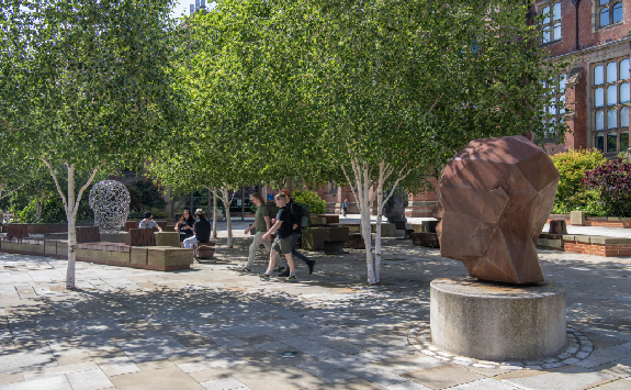 A detail of Generation by Joseph Hillier. Three large heads are built in bronze, steel, and stainless steel